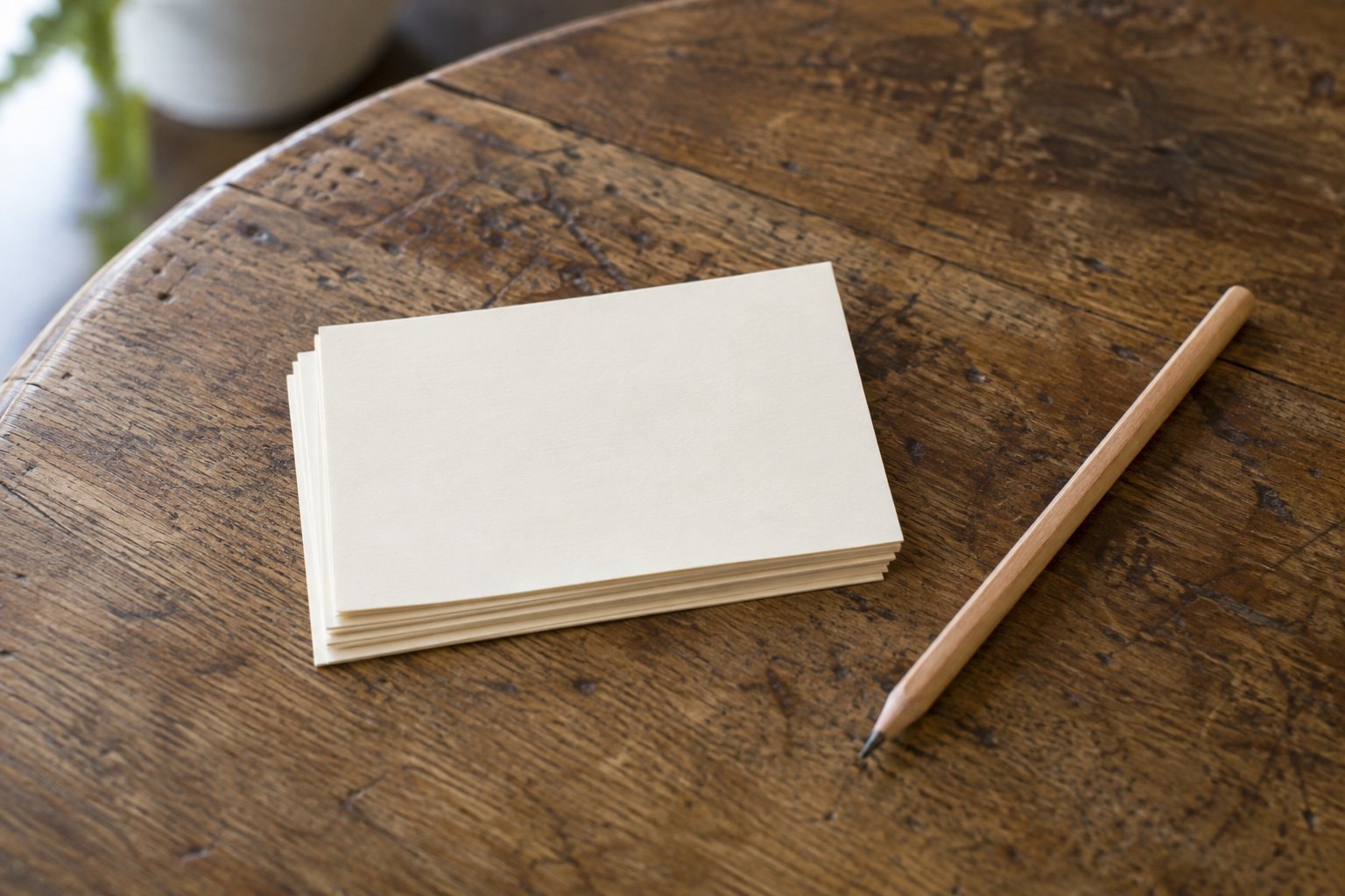 Blank index cards and a pencil on a café table.